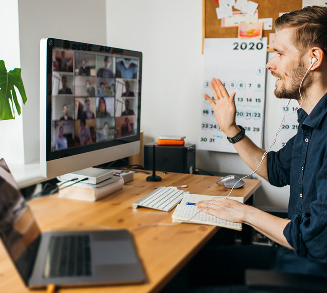 A manager leading a team meeting online from his desk